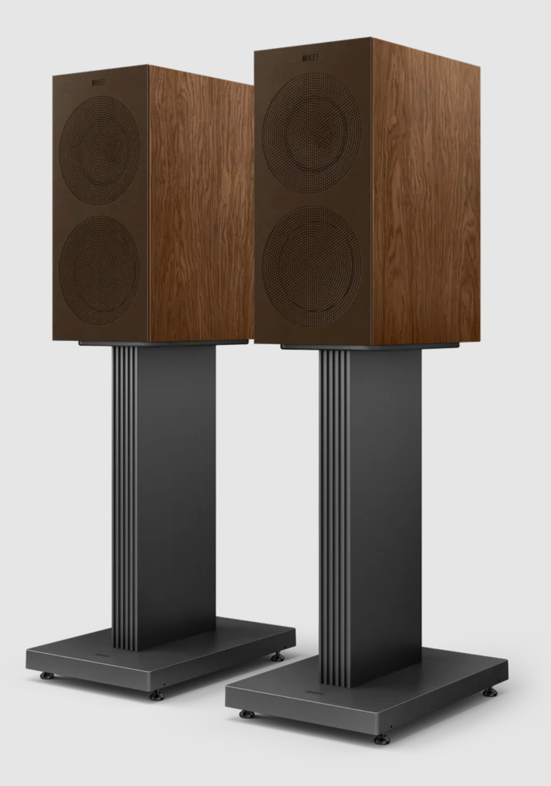 KEF R3 Meta Bookshelf Speakers in Walnut, with grille, on stands.